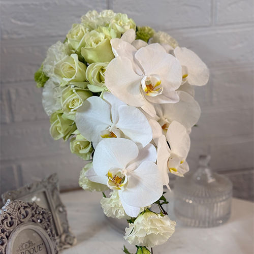 エレガントさと華やかさを兼ね備えた白胡蝶蘭と白バラのショートキャスケードブーケ